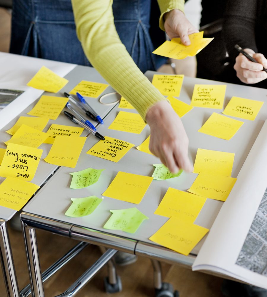 Cropped image of business people strategizing with sticky notes in office
